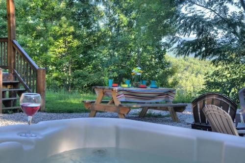 a picnic table with a glass of wine on it at Goldies Hideaway in Bryson City