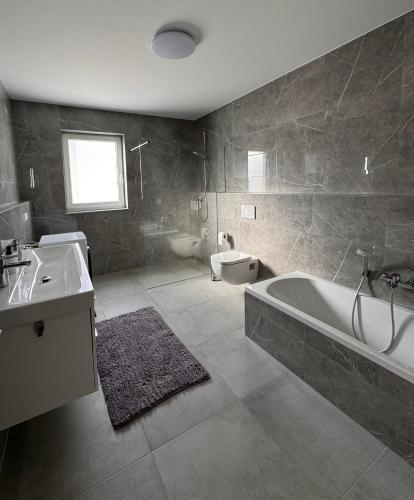 a bathroom with a tub and a sink and a toilet at Apartment Künzelsau II in Künzelsau