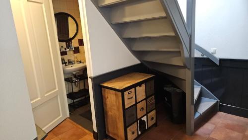 a bathroom with a staircase with a sink and a mirror at Spekenbrink in Haaksbergen