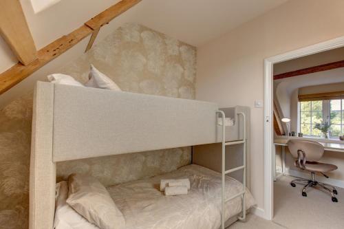 a bunk bed in a room with a desk at Fayette sleeps 4, 2 bedrooms, cute garden in North Creake
