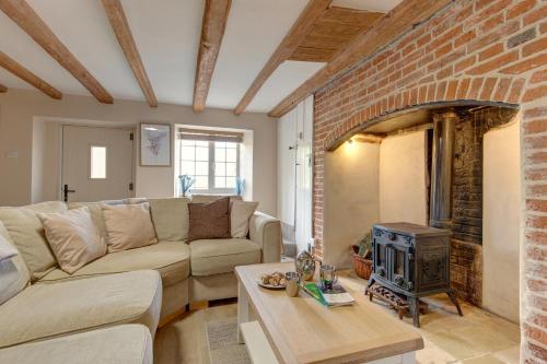 a living room with a couch and a fireplace at Fayette sleeps 4, 2 bedrooms, cute garden in North Creake