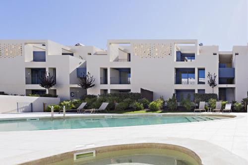 an apartment complex with a swimming pool in front of a building at Casas do Forte by MY CHOICE in Tavira