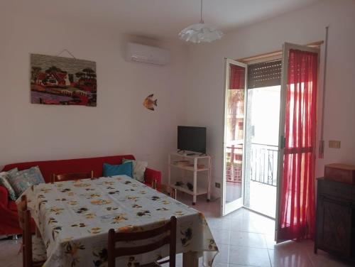a dining room with a table and a sliding glass door at casa LULU due minuti dal mare in Ardore Marina