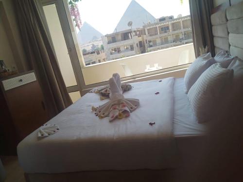 a bedroom with a bed with a large window at prestige pyramids INN in Cairo