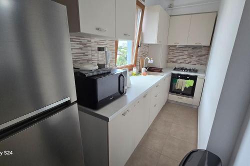 a kitchen with a refrigerator and a microwave at Ultra Central and Spacious with AC and Balcony in Iaşi
