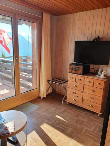 a living room with a television on a dresser at Hotel Rhoneblick in Guttet-Feschel