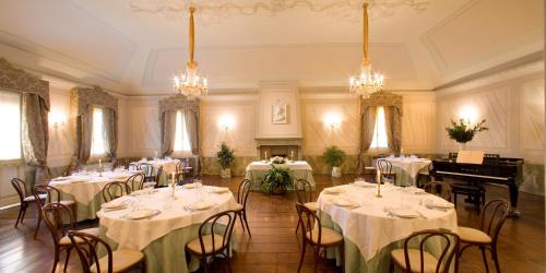 a banquet hall with tables and chairs and a piano at Alle Roncole in Busseto