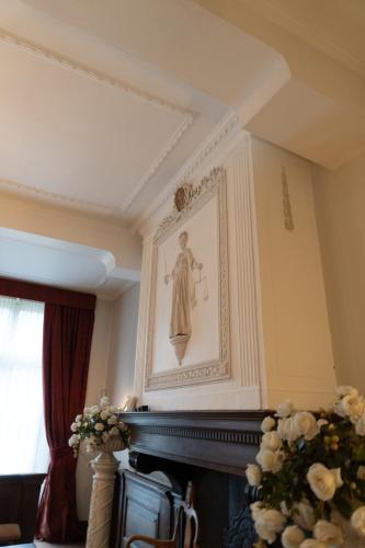a picture of a woman on a wall above a fireplace at Stadshotel Geertruidenberg in Geertruidenberg