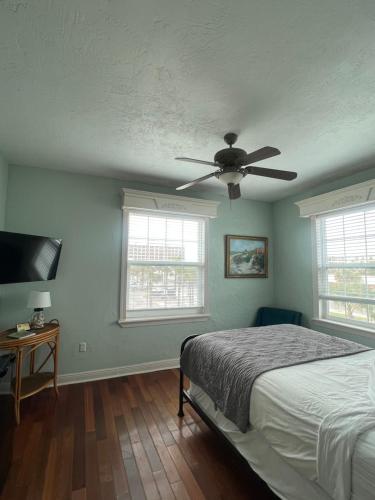 a bedroom with a bed and a ceiling fan at Casa Marina Hotel & Restaurant - Jacksonville Beach in Jacksonville Beach