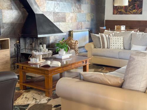 a living room with a coffee table and a fireplace at Cal Armengou in Castellar de NʼHug