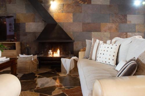 a living room with a couch and a fireplace at Cal Armengou in Castellar de NʼHug