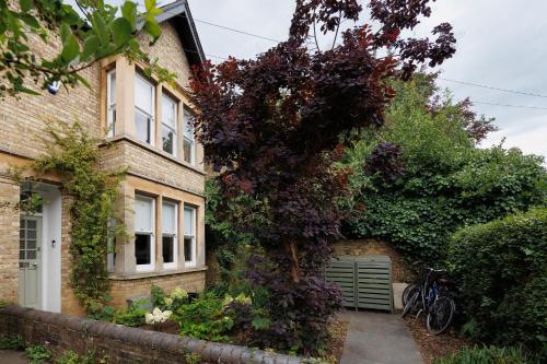a ivy covered house with a bike parked next to it at Beautiful Oxford Town House in Oxford