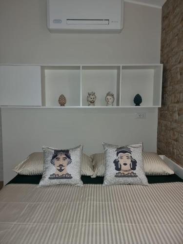a bedroom with a bed with pillows on it at La Trinacria casa vacanze in Bronte