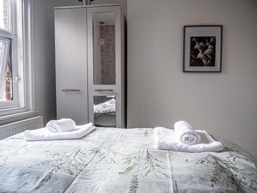 a bedroom with a bed with towels on it at Entire 5 Bedroom Comfortable House in Eastbourne in Eastbourne