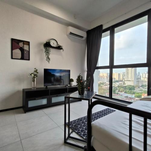 a living room with a bed and a tv at New Comfy Urban Suite Homestay at Georgetown for family by Urban Staycations LOD in Jelutong