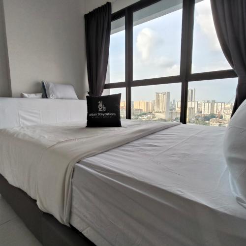 a bed with a pillow on it in a room with a window at New Comfy Urban Suite Homestay at Georgetown for family by Urban Staycations LOD in Jelutong