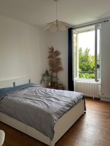 une chambre avec un lit et une fenêtre dans l'établissement Appartement 2 chambres - Proche gare, à Nevers