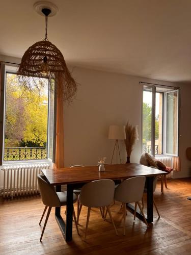 une salle à manger avec une table et des chaises et une fenêtre dans l'établissement Appartement 2 chambres - Proche gare, à Nevers