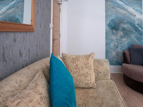 a couch with blue pillows in a living room at Entire 5 Bedroom Comfortable House in Eastbourne in Eastbourne