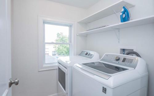 a white laundry room with a sink and a window at Jennifer's Penthouse 2 Floor Apartment - Amazing City View in Providence