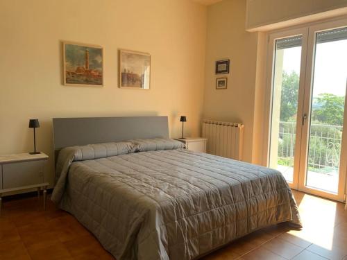 a bedroom with a bed and a large window at La casa di Giulio e Lina in Fossombrone