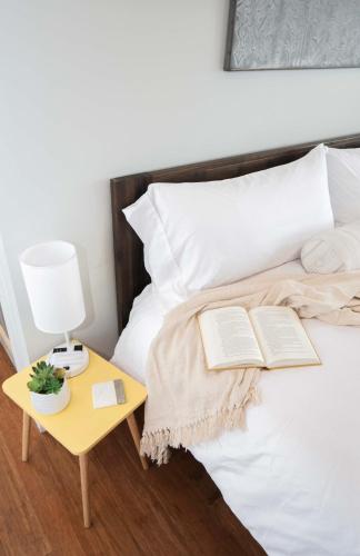 a bed with two books and a table with a lamp at Jennifer's Penthouse 2 Floor Apartment - Amazing City View in Providence
