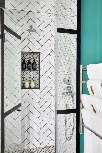 a bathroom with a shower with white tiles at Pineapple House Boutique Hotel in Cape Town