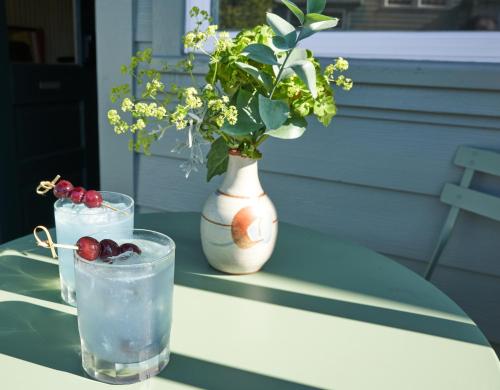 a vase with flowers and a drink on a table at The Drifthaven at Gearhart in Gearhart