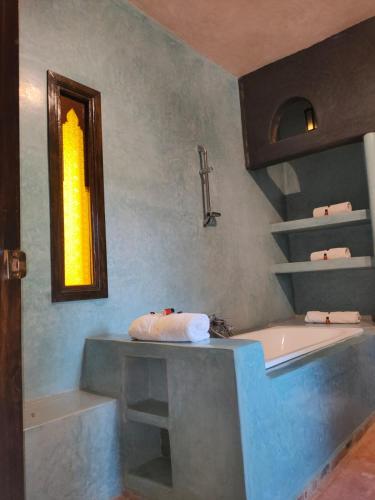 a bathroom with a tub and a cross on the wall at Riad shéhérazade Marrakech in Marrakesh