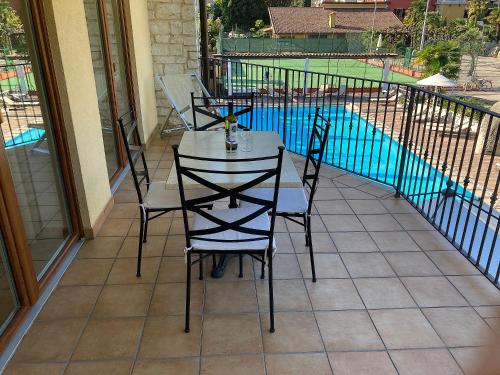 a table and chairs on a balcony with a pool at Residenza Le Due Torri in Riva del Garda