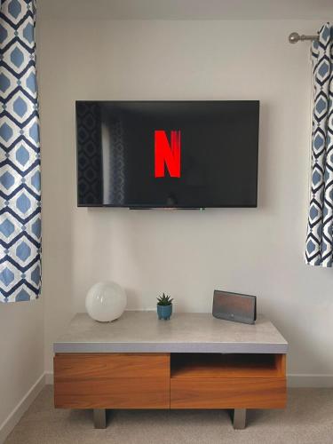 a tv hanging on a wall with avertisement at Bright 2-bedroom apartment with parking in Montrose in Montrose