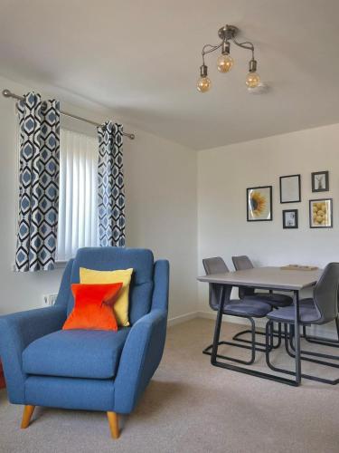 a living room with a blue chair and a table at Bright 2-bedroom apartment with parking in Montrose in Montrose