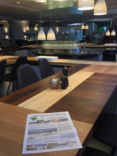 a newspaper on a wooden table in a restaurant at ´t Wapen van Marion in Oostvoorne
