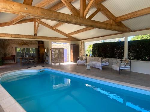 - une piscine dans une maison dotée d'un plafond en bois dans l'établissement Au charme de la Cour, à Auxonne