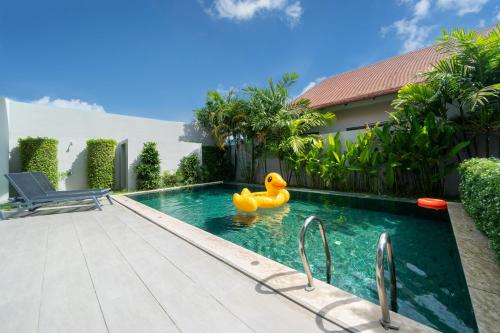 a rubber duck in a swimming pool next to a house at 宽敞舒适 邦涛海滩Laguna附近 三卧室私人泳池别墅 in Phuket Town