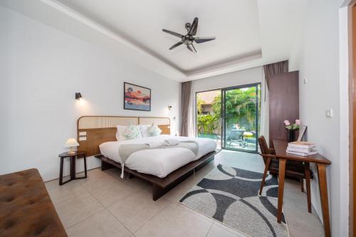 a bedroom with a bed and a ceiling fan at 宽敞舒适 邦涛海滩Laguna附近 三卧室私人泳池别墅 in Phuket Town