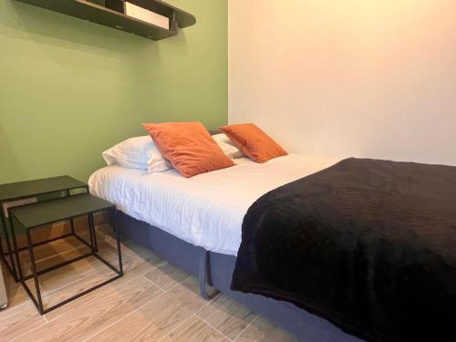 - 2 oreillers orange sur un lit dans l'établissement Fully equipped Studio - 4 mins from the metro, à Paris