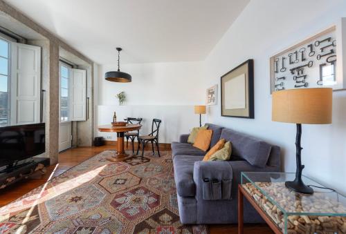 a living room with a blue couch and a table at Porto Premium River View II in Porto
