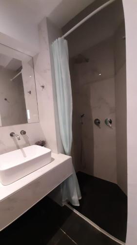 a white bathroom with a sink and a shower at Dorian in Kos Town