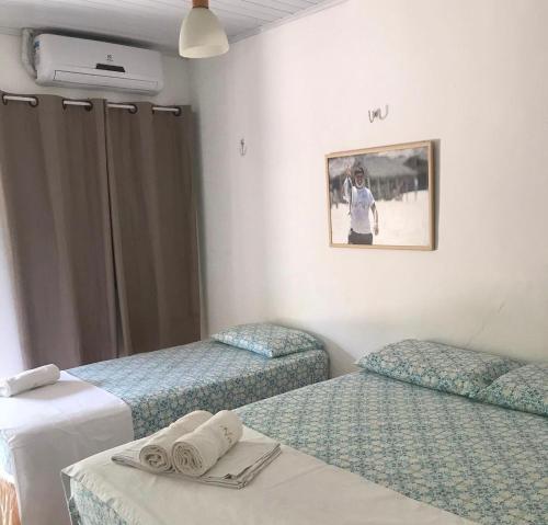 a room with two beds and a picture on the wall at Luar Da Barra in Barra Grande