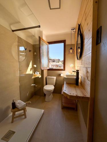 a bathroom with a toilet and a sink and a shower at Cal Armengou in Castellar de NʼHug
