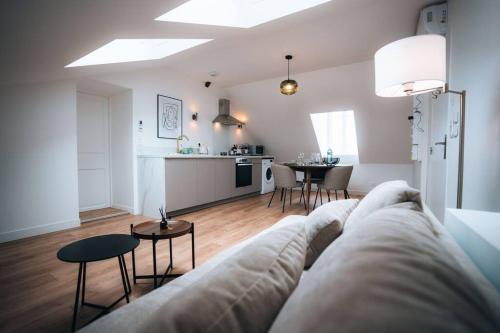 a living room with a couch and a kitchen at Le Berry Sweet - La Douceur de vivre - Proche Gare in Châteauroux