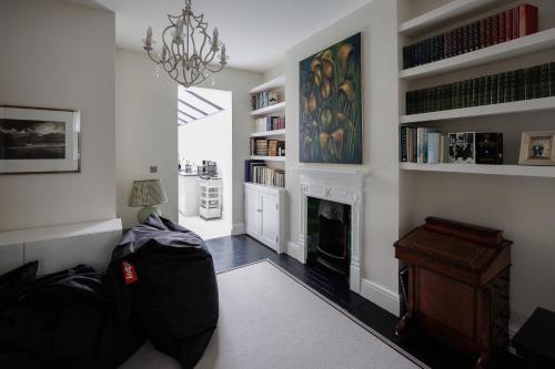a living room with a fireplace and a chandelier at Beautiful Oxford Town House in Oxford