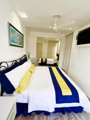 a bedroom with a large bed with yellow and blue stripes at Hotel Presidente Vicente Guerrero in Chilpancingo de los Bravos