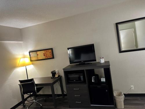 a room with a desk and a television on a wall at Quality Inn in Sarnia