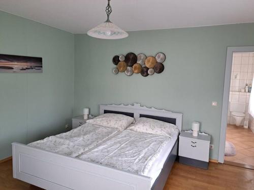 a bedroom with a white bed and a white wall at Ferienwohnung direkt am See 2 in Altmünster