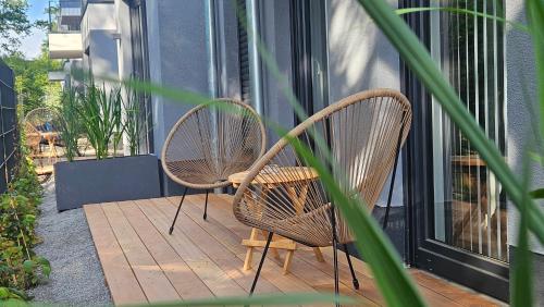 two wicker chairs sitting on a wooden deck at Townlofts am Borussia Park in Mönchengladbach