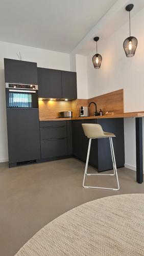 a kitchen with a white chair and a counter at Townlofts am Borussia Park in Mönchengladbach
