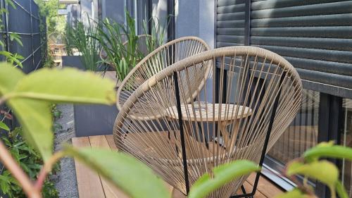 a wicker chair sitting on a deck with plants at Townlofts am Borussia Park in Mönchengladbach