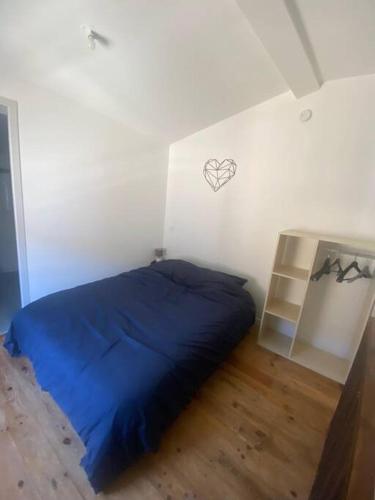 - une chambre avec un lit bleu et un mur blanc dans l'établissement Charmante Maison entre Castres & Mazamet, à Aiguefonde
